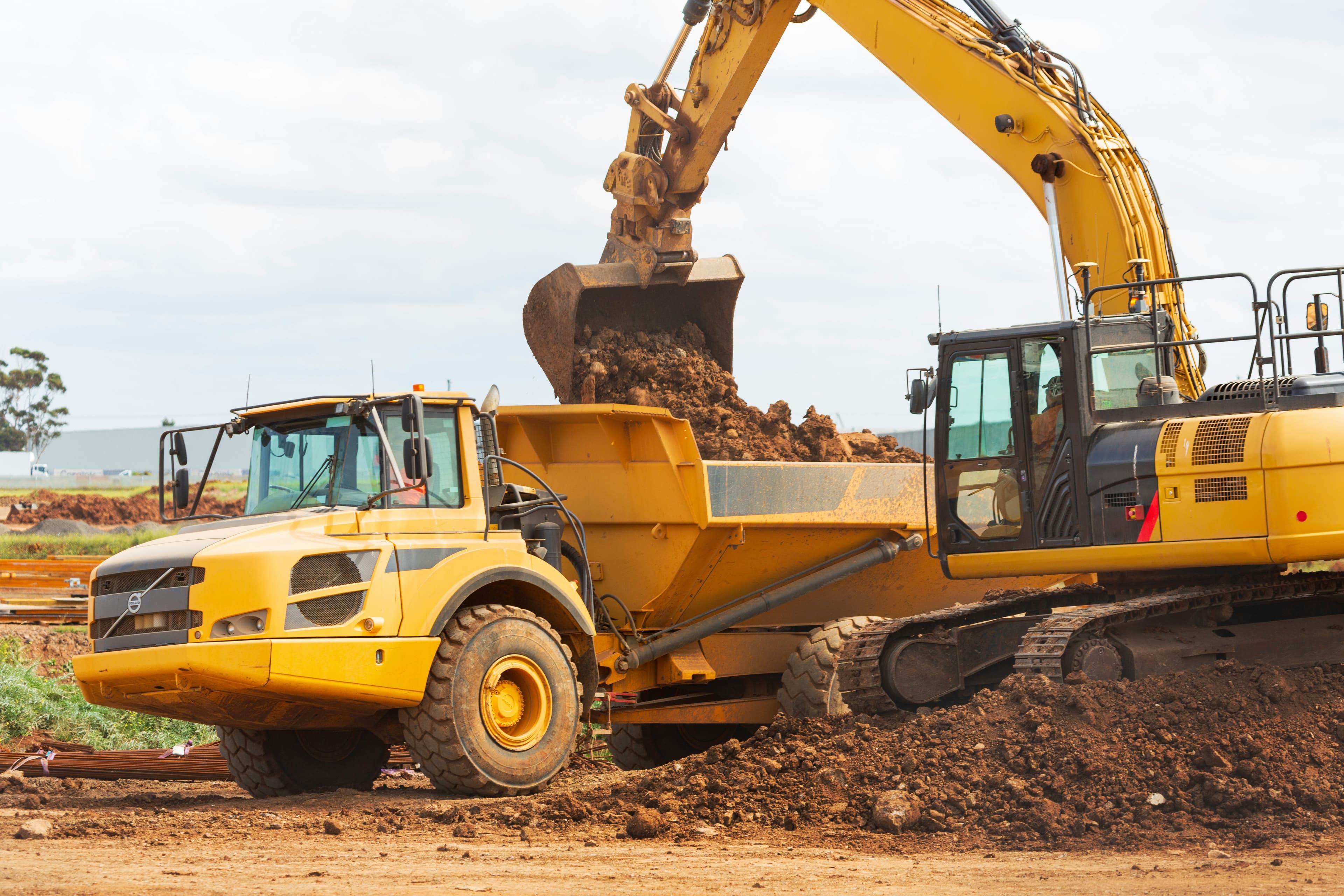 Yellow excavator on a construction site at dusk.